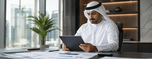 "محترف سعودي يراجع المستندات المالية في مكتب حديث"